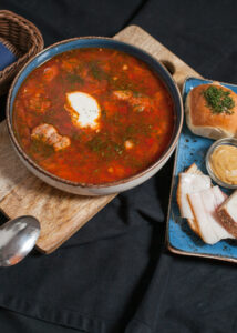 Barszcz ukraiński z mięsem, śmietaną, pampuchem i słoniną w restauracji Pieczony Dzik we Wrocławiu