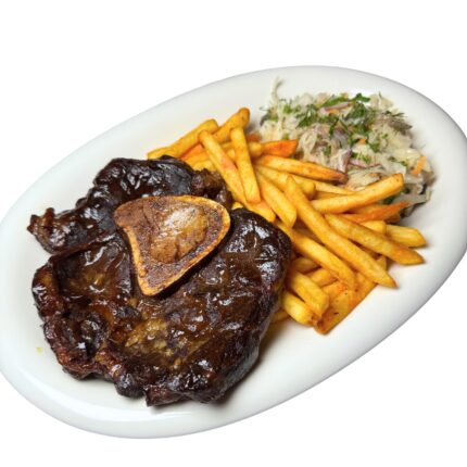 Barbecue ribs with sauce, French fries, and coleslaw on a white plate.